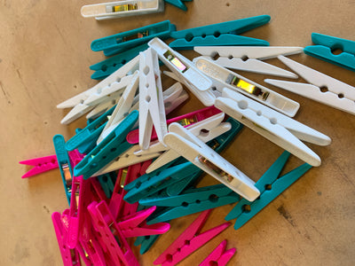 Pack of 140 plastic pegs that are used as clamps